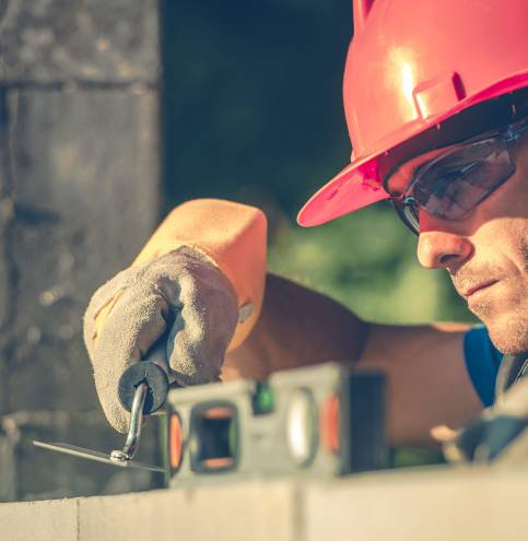 Caucasian Masonry Worker in Hard Hat. Construction Site Theme.